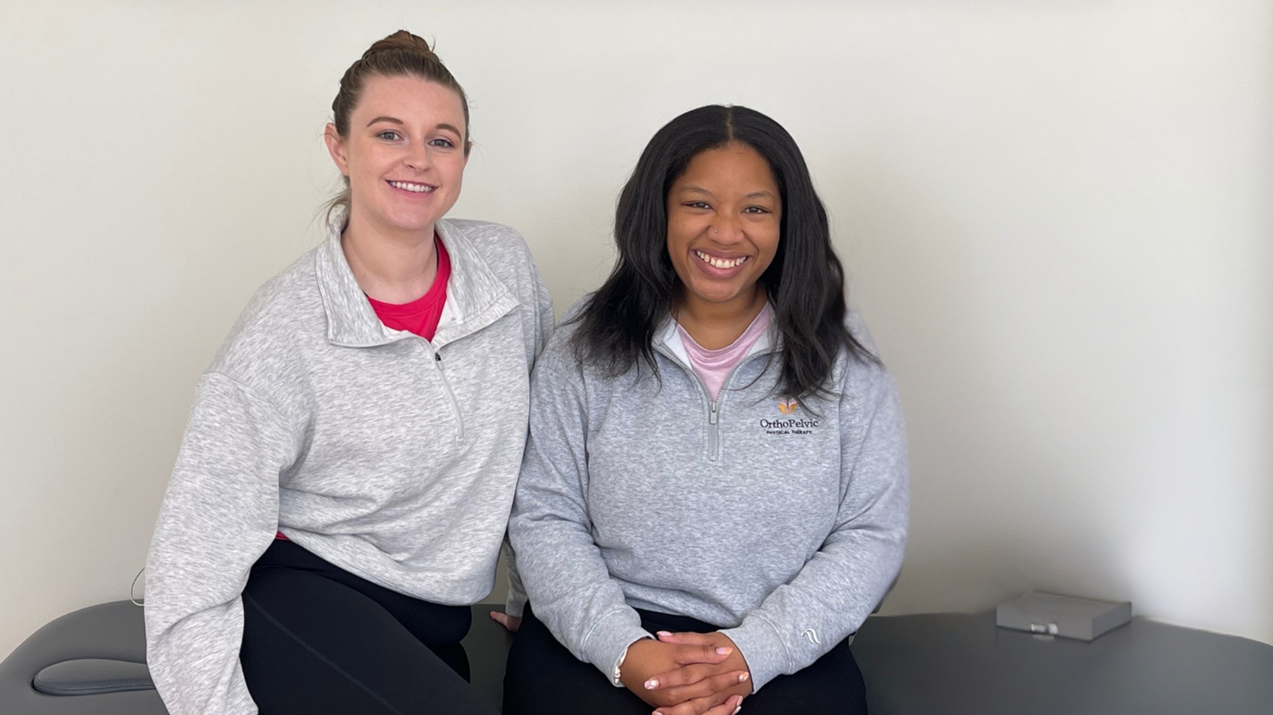 Dr. Skyler and Dr. Amaya pelvic floor physical therapist of Sterling, VA sitting and pleasantly smiling on treatment table.